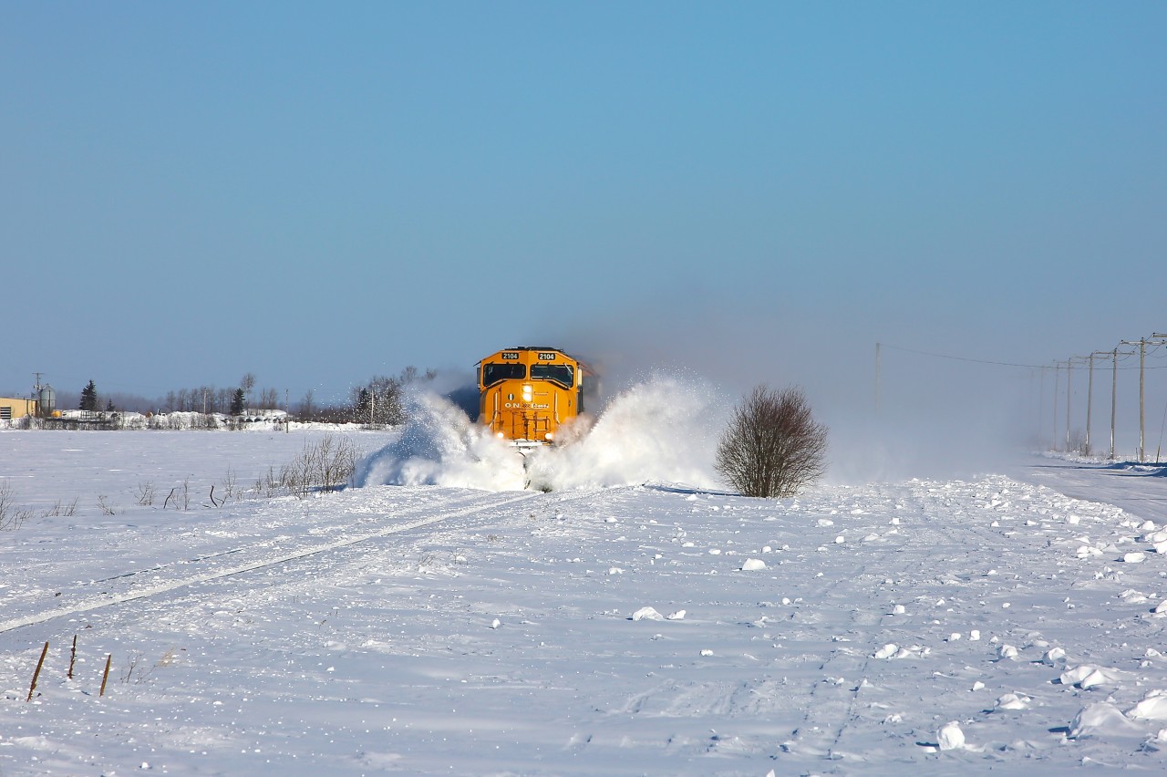 2104 hits a few small snow drifts as it leads train 214 through the farmed fields north of Earlton.  This area, which is quite open, seems to be prone to drifting and on this windy morning the hollows had already begun to fill in even though 113 had been through only an hour or so prior.