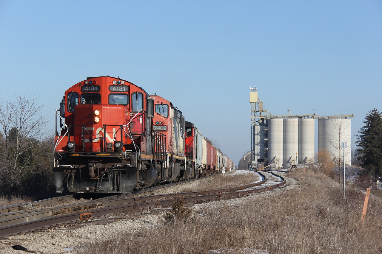 CN A431 led by GP9 4131, CN 2409 and a CN wide cab GP unit begin to switch at Shantz Station in Breslau, ON on a sunny snowless January Friday. This train ran into some trouble further east and thus needed the assistance of 4131 to make the grade. The lighting was great but unfortunately I had to get back to work so couldn't get more shots in Kitchener. Definitely nice to see the return of CN to this line.