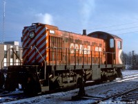 White smoke gently puffs from her stack as CP S3 switcher 6540 idles outside the yard office at Lambton Yard on a cold December morning while awaiting her next assignment. She was one of a handful of Alco/MLW S-series switchers that worked the Toronto area switching yards and working the local freights that served industry located along the lines. Many of CP's switchers ended up spending most of their lives assigned to and working in one area or region, and according to photos and assignment sheets 6540 was one of the longtime local gals that spent most of her life assigned to John Street Roundhouse downtown, where CP's 539-power was serviced and maintained for the Toronto area.<br><br>The non-turbocharged 660hp S3 model was favoured by CP in the latter part of dieselization due to lower maintenance costs (no turbo) and also what CP deemed an adequate amount of power for most switching activities (for those that required more, CP employed its already-numerous 1000hp S2 units). As time went on, the aging switchers were found to be underpowered for the increasing train and freight car weights. Some were MU'ed together for heavier tasks at various terminals (including flat-switching at Toronto Yard), while others were gradually retired and sold off to industries, shortlines or for scrap as larger power replaced them. Some like 6540 clung on to yard and local assignments into the 1980's until what remained of the old 539-powered switcher fleet was finally retired and replaced by more powerful rebuilt GMD units (6540 was retired in January 1983, and scrapped at CP's Angus shops in Montreal).<br><br><i>Original photographer unknown/not noted, Dan Dell'Unto collection slide</i>.