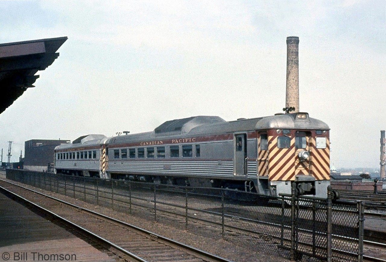 CP RDC-2 9109 and a 90xx-series RDC-1 are seen passing the platforms at CP's Westmount Station in Montreal QC.

CP 9109 was built in 1955 by Budd as an RDC-2 (passenger seating with a small baggage area), later rebuilt into an "RDC-5" by CP in the mid-70's (RDC-5 was CP's term for an RDC-2 converted into RDC-1 with the baggage section removed and more seating), and was sold to VIA in 1978 to became VIA 6138. It was eventually retired by VIA and sold to Farmrail in 1999, and languished at VIA's Toronto Maintenance Centre where it remains to this day.