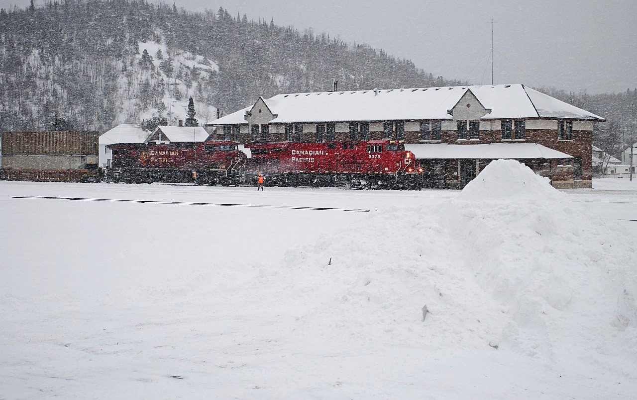 It's December 2014 in Schreiber ON.   While the CPRail Holiday train entertains the residents I wander over to the station which serves as the crew change point and formerlly contained the dispatchers.  A westbound intermodal train wanders in from the east and changes crews in a heavy storm.  Then the engines wind up and the train leaves for Thunder Bay.