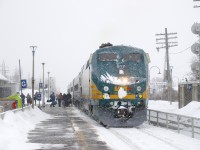 VIA 26 from Ottawa is making its station stop at Dorval on a snowy afternoon. The train consists of VIA 917 and four stainless steel cars.