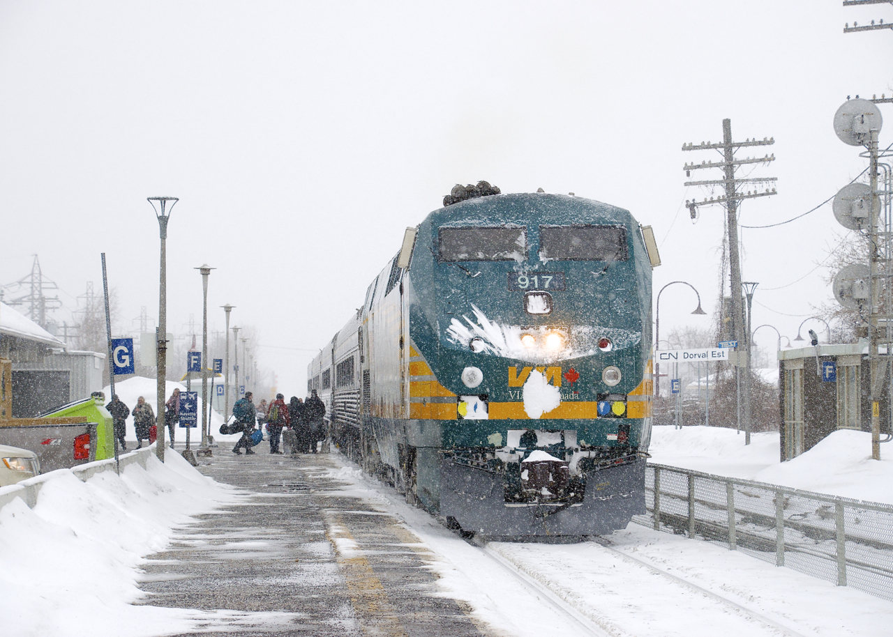 VIA 26 from Ottawa is making its station stop at Dorval on a snowy afternoon. The train consists of VIA 917 and four stainless steel cars.