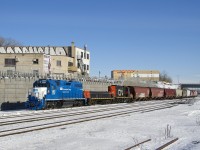 The Pointe St-Charles Switcher has left its namesake yard with empty grain cars destined for Taschereau Yard as it heads west on the transfer track of CN's Montreal Sub with leased GMTX 2257 leading and CN 227 and CN 7233 trailing. Up until the end of last summer the tracks curved off to the right here, but they now curve off to the left since a new right-of-way entered service then.