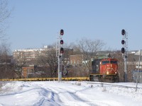 CN X312 (operating as CN 310, as the crew was called for CN 310 and X312 will be combined with 310 at Southwark Yard a bit further ahead) rounds a curve in St-Henri, with CN 5651 solo and empty flats headed to the Gaspé Peninsula for another load of windmill blades.