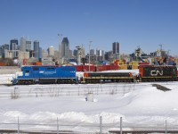 The Pointe St-Charles Switcher is getting ready to leave its namesake yard and pick up a single bad ordered autorack a few miles west of here. Power is GMTX 2257, CN 227 and CN 7233, with the skyline of downtown Montreal in the background.