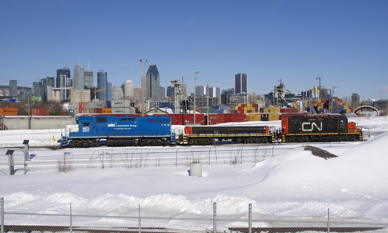 The Pointe St-Charles Switcher is getting ready to leave its namesake yard and pick up a single bad ordered autorack a few miles west of here. Power is GMTX 2257, CN 227 and CN 7233, with the skyline of downtown Montreal in the background.