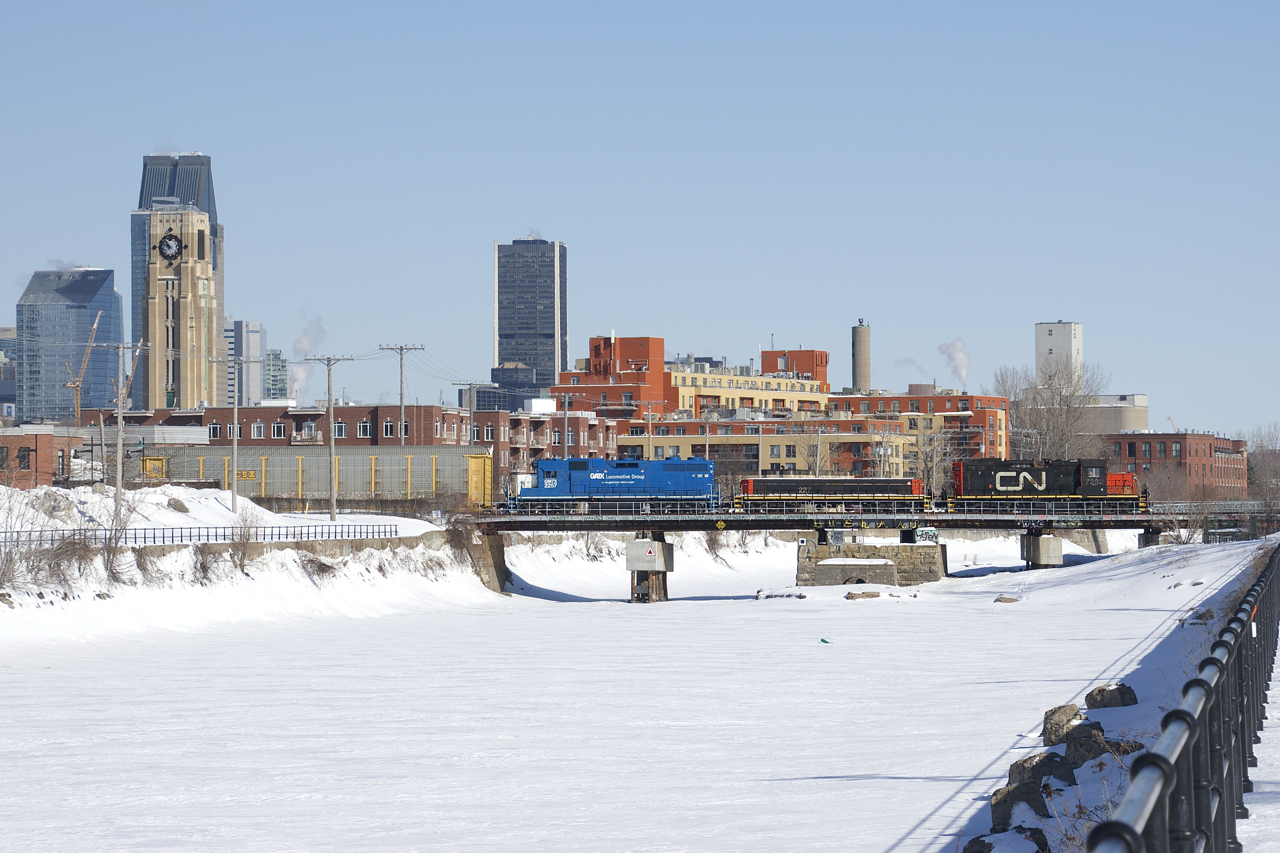 The Pointe St-Charles Switcher is crossing the Lachine Canal on its way back to its namesake yard with single bad ordered autorack in tow (picked up on track 29 just west of the De Courcell crossing). Power is CN 7233, CN 227 and GMTX 2257.