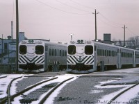 A gloomy winter Saturday at the VIA-GO Georgetown Station finds GO Transit single-level Hawker Siddeley cab cars 101 and 106 sitting on the head-end of their consists, plugged in to the wayside power outlets (that provide trains with power and heating while on layover) in the Georgetown commuter compound. Since it's the weekend, the two won't see any use until rush-hour commuters swarm the platforms on Monday morning.  <br><br> The Hawker Siddeley Canada single-levels were the original equipment designed for and purchased by GO Transit for their initial startup in the mid-60's. After retirement from GO in the 90's, 101 & 106 (along with the bulk of the fleet) would go on to second careers in Montreal commuter service as AMT 202 and AMT 106 respectively, earning the nickname "GO Karts". AMT retired them in 2010, but sister car 104 would be repatriated by GO Transit in 2017 for its 50th anniversary, restored and donated to the TRHA for display at their museum in downtown Toronto. <br><br> <i>Bill McArthur photo, Dan Dell'Unto collection slide</i>.<br><br> For some Tempo train action that Bill shot on the same visit: <a href=http://www.railpictures.ca/?attachment_id=44451><b>http://www.railpictures.ca/?attachment_id=44451</b></a>