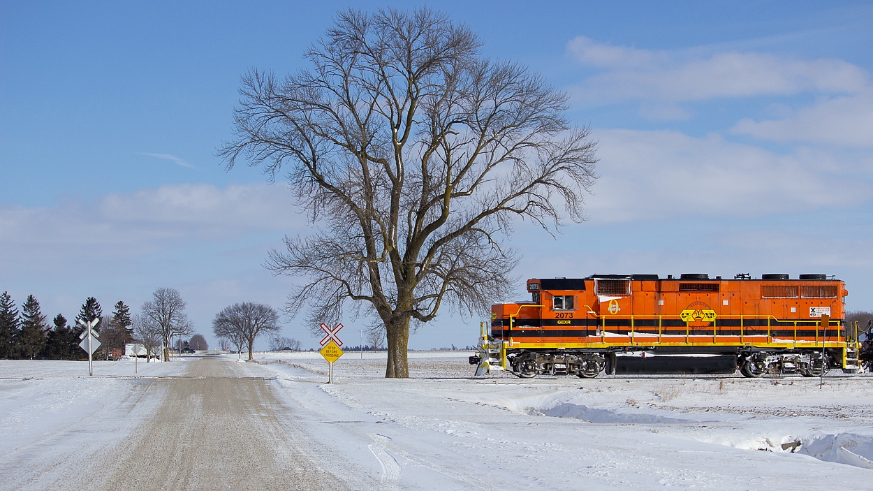 GEXR 2073 on point of GEXR 581 as they charge northward at a leisurely pace of roughly 15mph outside of Hensall, Ontario after lifting a lone boxcar at Exeter, Ontario. It was quite the switching maneuver performed to boot. Here they are crossing over Walnut Road. Walnut Road is the first side road north of Hensall. A big thanks to my buddy Jamie Knott for fixing this gem for me, I still haven't mastered editing yet and am very slowly learning the basics. The original was slightly out of level and he also made a few other adjustments for me. I'm not sure what the species of tree is in the shot, but one can only surmise it might be a a Walnut since it's on Walnut Road.