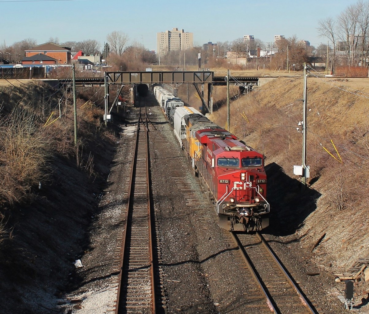 CP 240 emerges from the Detroit River rail tunnel on a sunny Saturday afternoon. About 3 minutes earlier, an ETR local passed over the bridge in the background. One day I will get an over/under meet here between CP and ETR. The tunnel between Windsor and Detroit was built in 1910 by the Michigan Central Railroad and has gone through some major transformations, and different owners over the years. Today CP owns the tunnel and is the only railroad that uses it regularly, compared to a few decades ago when multiple railroads ran trains through it. The tunnel was enlarged in 1994 to accommodate excess height traffic, but still cannot handle large cubed double stack intermodal.
