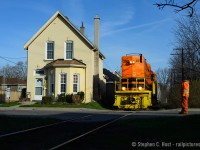 It's hard sometimes to think of the scale of what we photograph, but trains are actually quite large. This photo should put it into perspective, as 'house sized' QGRY 2301 passes a dwelling at the corners of Rose and Port St in Brantford, at 0800 back in 2015.<br><br>One can't mistake the correlation between the safety vest of SOR 598's conductor and the paint on QGRY 2301. A friend called G&W the "Safety Vest Railway" and I agree.  Photo notes: Nikkor 50mm f/1.8 on my full frame D800.