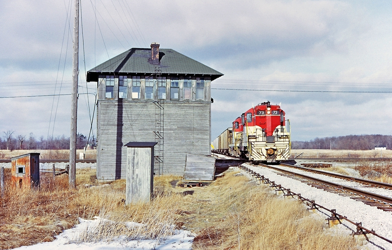 A splendid slide taken by Bruce Mercer way back January 8, 1973. The image shows  TH&B 73 leading the East Local, "Port Maitland job" over the diamond at E&O tower and the the NYC / PC CASO SUB. The east local by time table direction is actually a southward movement on the TH&B Dunnville sub was south and north direction whereas all the other TH&B subs were east and west. The interlocked crossing at E&O was mile 9.46 on the TH&B Dunnville sub and less than half a mile from the location the TH&B went over the CN Cayuga sub, mile 9.80, both of these "railway crossing at grade" were interlocked and controlled by a tower man, sometimes referred to as a lever man or signalman. All the signals governing  TH&B movement through the interlocking were of the semaphore type.  TH&B Dunnville sub had another crossing at mile 14.28 of the CN Dunnville sub. The Dunnville sub crossing the Dunnville sub. It was an automatic interlocking.