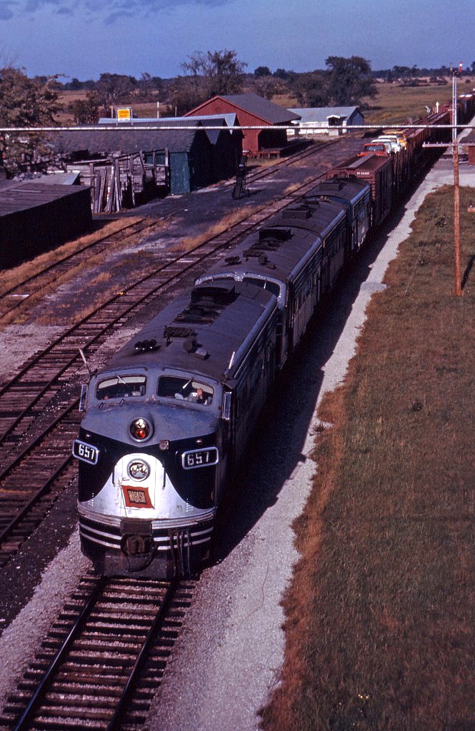 Although the Wabash has recently been acquired by the Norfolk & Western (October 1964), there are no signs of the change in ownership as an extra west rolls though Cayuga behind four F7As on a fine late fall/early winter day in 1964.