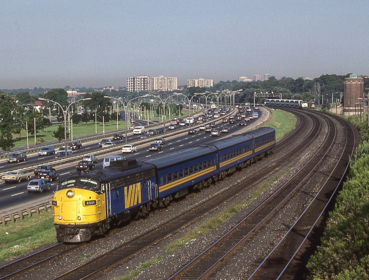 VIA 6541 is in Toronto heading east to Toronto Union Station on August 9, 1987. In the background under the signal bridge is a GO train.