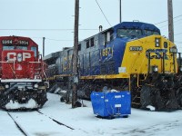 A snowy day on the old fuel stand has a CP SD40-2 with big brute 6000 horsepower AC60W CSX 687. The twin lightning stripes by the cab number on the CSX unit indicates AC power.