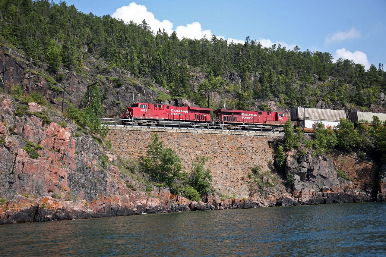 CP 113 lead by 8909 hugs the spectacular shoreline of Lake Superior as she passes through Cavers. The area is renowned for tunnels, rock cuts and slide fences.  It was one of the most expensive areas to build when the CPR first crossed the country.  The original "cornerstone" is still part of this beautiful wall, and is a credit to the great workmanship that went on in those days.