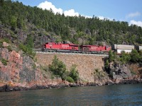 CP 113 lead by 8909 hugs the spectacular shoreline of Lake Superior as she passes through Cavers. The area is renowned for tunnels, rock cuts and slide fences.  It was one of the most expensive areas to build when the CPR first crossed the country.  The original "cornerstone" is still part of this beautiful wall, and is a credit to the great workmanship that went on in those days.   