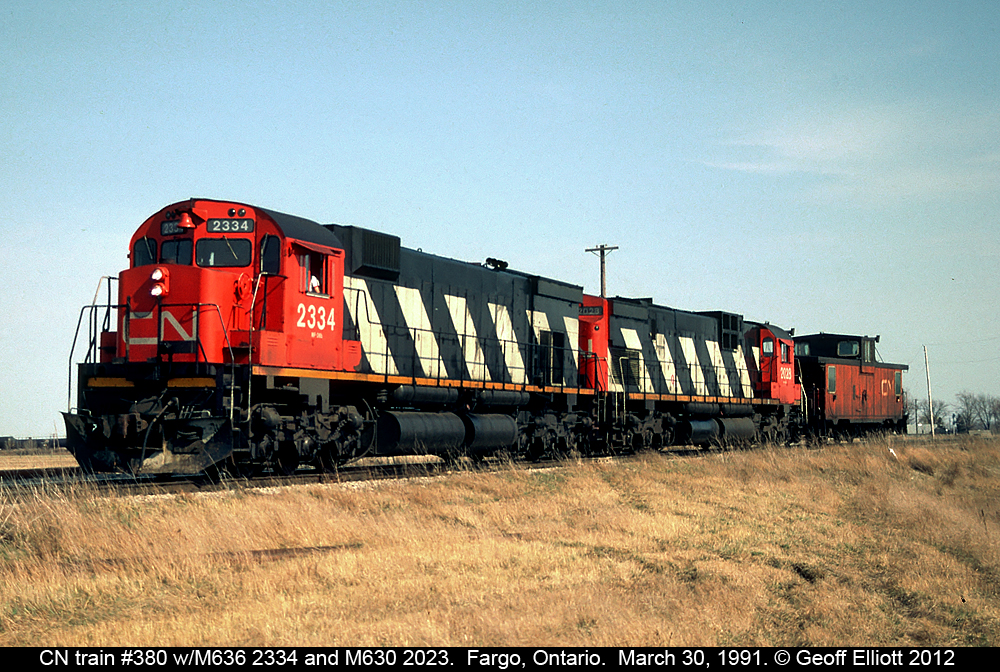 A late CN Train #380 runs as a caboose hop from Windsor to London with M636 #2334 and C630 #2023 as power back on March 30, 1991.  #380 is swinging through the connection track at Fargo, Ontario from the CN CASO Sub to the C&O #2 (Sarnia) Subdivision to makes it's run to Chatham.  In Chatham #380 will swing east through the connection and onto the CN Chatham sub to then continue east to London.  Miss these days......