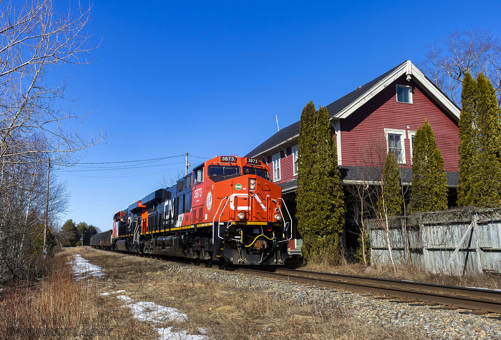 Still sporting it's new paint smell, a pair of brand new AC's (3874 trailing), lead train 406, as they pass by the old railway station in Rothesay, New Brunswick. It's not very often that power this new makes it down on this subdivision.