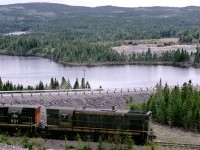 CN 800 is passing Goose Cove south of Trinity, Newfoundland on its return from Bonavista on the 80-mile trip to Clarenville with mixed Train 206.   It is about 3 p.m. on a June day in 1973, and engineer Bill Mornell widens on the throttle to begin the ascent of Heartbreak Hill to the famous Trinity Loop.  Trailing unit 801 leads three boxcars and combine 6016.   At this time, Trains 205 and 206 ran tri-weekly on Monday, Wednesday and Friday.  G8a 800 had a long history on the former Newfoundland Railway. It was built by GMDL in London in June 1956, retired in December 1986 and scrapped at Whitbourne in 1988. For more images from this and other chases on the Bonavista branch and throughout Newfoundland, please contact me at bill.linley@gmail.com to obtain a copy of my just-released book “Trackside Newfoundland.”