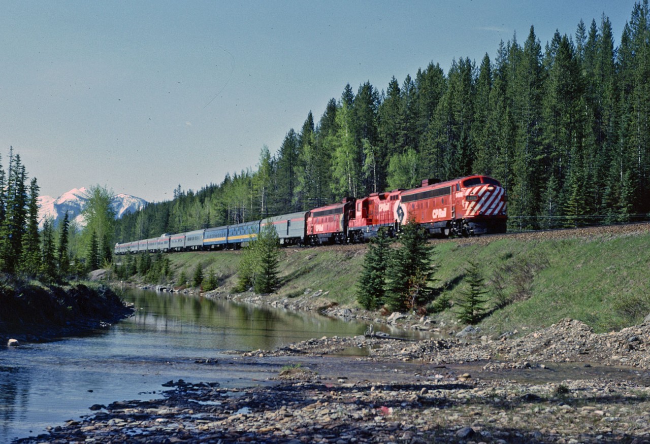 Under beautiful mountain skies, VIA 2, the Canadian is 14 miles from the division point of Field BC.  The colourful consist shows the varied heritage of much of the equipment.