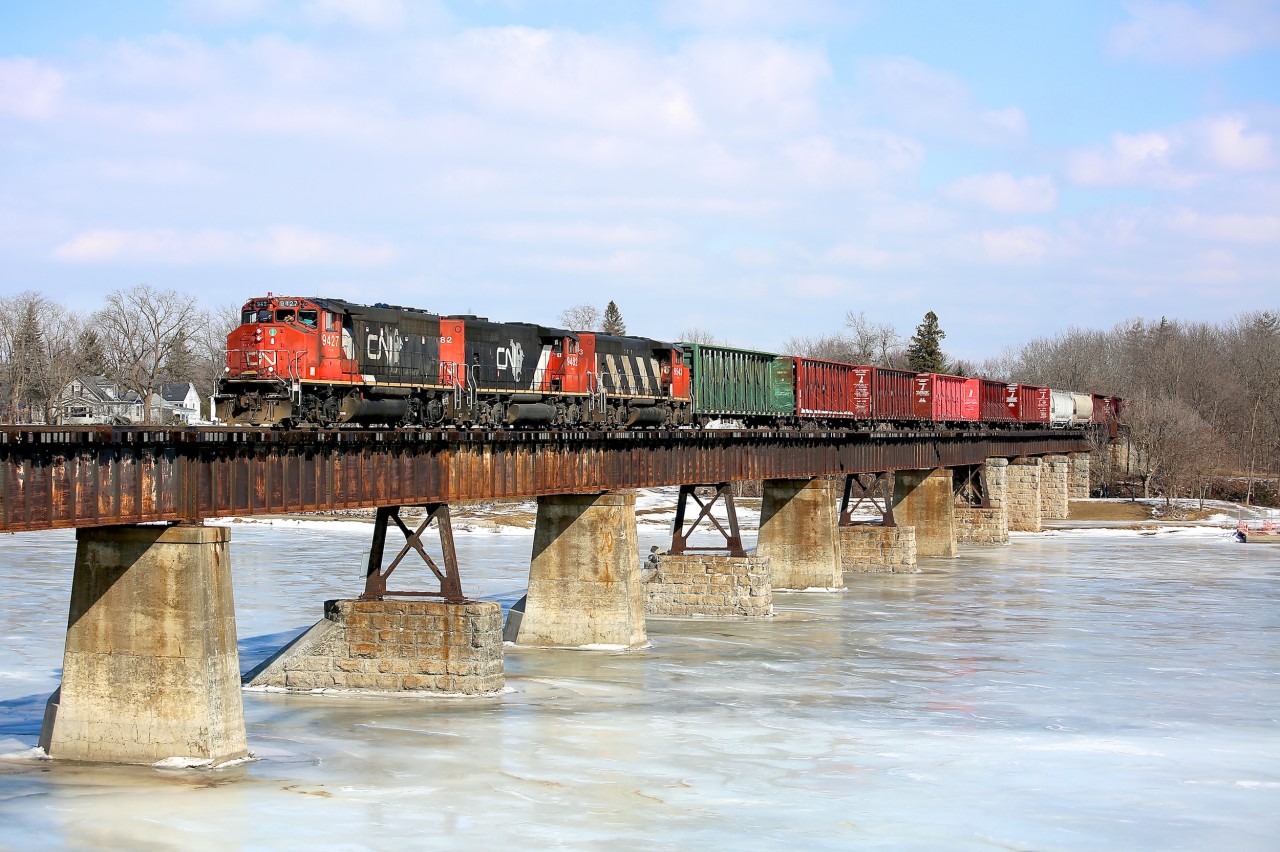 A trio of CN GP40-2L(W) locomotives power train 580 over the Grand River at Caledonia, ON.  The train is headed south with empty hoppers and centrebeams for CGC in Hagersville.