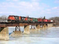 A trio of CN GP40-2L(W) locomotives power train 580 over the Grand River at Caledonia, ON.  The train is headed south with empty hoppers and centrebeams for CGC in Hagersville.