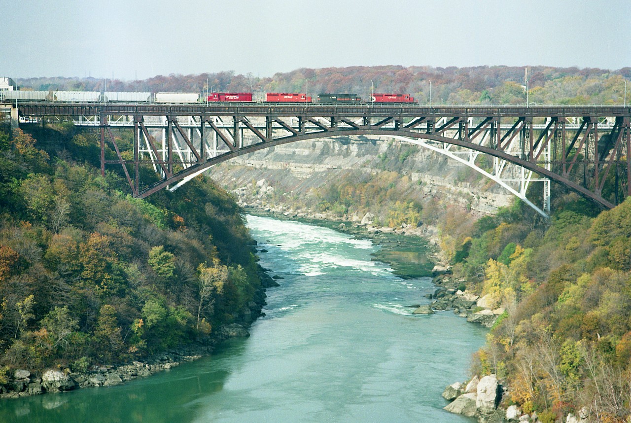 Four SDs lead the daily Toronto-Buffalo manifest freight over the old Michigan Central bridge into the USA on a late fall afternoon. Power is CP 5609, HATX 512, CP 5918 and 5655. All units have different paint variations; the last with the shortlived "dual-flag" scheme.
I'm glad I managed a few shots here, as it was only another 6 years or so and trains thru CPs downtown Niagara Falls line would be silenced forever. There was talk of dismantling the bridge, but, at the time the cost of $25 million just to tear it down seemed oppressive. So, even today, there it rusts.