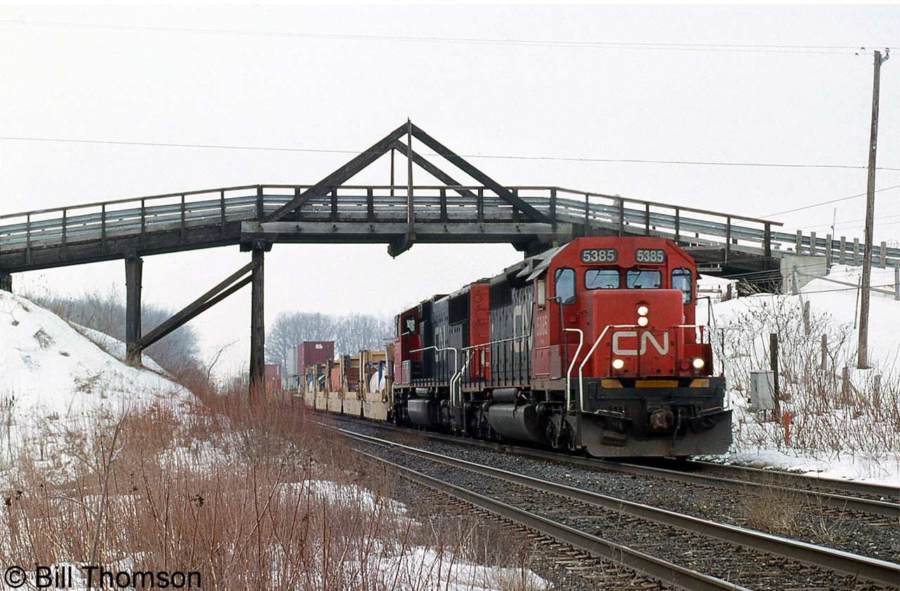 CN SD40-2 5385 and SD75I 5787 head an eastbound intermodal under the old wooden bridge at Frank's Lane on the Strathroy Sub at Lobo Siding (the name of a hamlet just west of London).