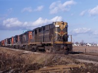 On a snow-less day in January 1967, a CN freight heads through Welland on its way to Fort Erie. Between deliveries of new locomotives and repaints, the "1961 image" is now very common, although you could still occasionally catch units in the "old colours"...trains with three or four 4-axle units were quite common at that time, often intermixing RS18s with GP9s as well as GP40s and C-424s. (The SD40/C630 era had not yet arrived.)