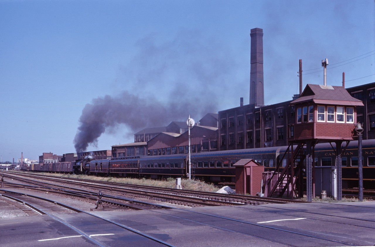 On 6 July 1963, the UCRS sponsored an excursion from Toronto to Aurora (with two side trips to Bradford), coinciding with Aurora's centennial. The train is seen passing over the grade crossing at Strachan Avenue on the Brampton sub (the Weston and Halton subs not having yet been established)and still guarded by a crossing watchman's tower. Note the industries and service tracks (now long-gone), as well as the double track CP Galt sub in the foreground. Now which is more fascinating...the 6167 or the railroad scene some 55 years ago?