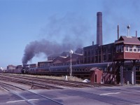 On 6 July 1963, the UCRS sponsored an excursion from Toronto to Aurora (with two side trips to Bradford), coinciding with Aurora's centennial. The train is seen passing over the grade crossing at Strachan Avenue on the Brampton sub (the Weston and Halton subs not having yet been established)and still guarded by a crossing watchman's tower. Note the industries and service tracks (now long-gone), as well as the double track CP Galt sub in the foreground. Now which is more fascinating...the 6167 or the railroad scene some 55 years ago?