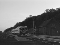 The year 1962 was one of changes in passenger train service in southern Ontario. A previously discussed, with the April 29, 1962 timetable the long-established practice of pulling westward passenger trains into Hamilton and then backing out to Bayview was eliminated (except for No. 15, the westbound/overnight International Limited) and Chicago Trains such as No. 5, the LaSalle, now departed Toronto at 6:00 PM, stopping at Dundas at 7:00 PM. CN instituted a connecting train service to/from Niagara Falls via Hamilton. In this photo, we see an RDC2 and an RDC1 in front of the Dundas station having arrived from Hamilton and the Grimsby sub at 6:35 PM. They will turn as train No. 696 and arrive in Hamilton at 7:15 PM and Niagara Falls at 8:40 PM. Similar connecting trains met Nos. 14 (International Limited) and No. 17 (Intercity Limited) at 8:31 and 9:00 AM; and No. 6 the Intercity Limited at 2:06 PM. Patronage must have been light--by the October 28, 1962 timetable this service had ended except for a Sundays-only Budd car which met no. 5.

(Note: this is another badly degraded slide restored as best we can and posted because its unusual subject matter.)