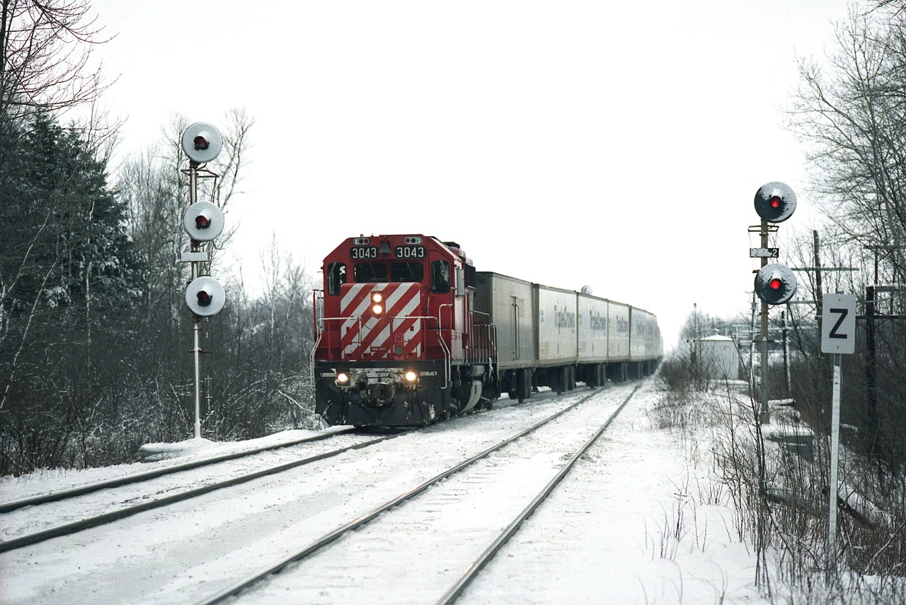 Just entering western limits of Guelph Jct, CP's now defunct Triple Crown Roadrailer train crosses to south track, running eastbound behind CP 3043. Wet sticky snow fell overnight, powered by strong wind, and that had me itching to head up to the Jct for morning activity on my day off from work. The T.C. was handed off from NS in Detroit, destination Toronto. It ran eastward daily except Monday and Saturday.