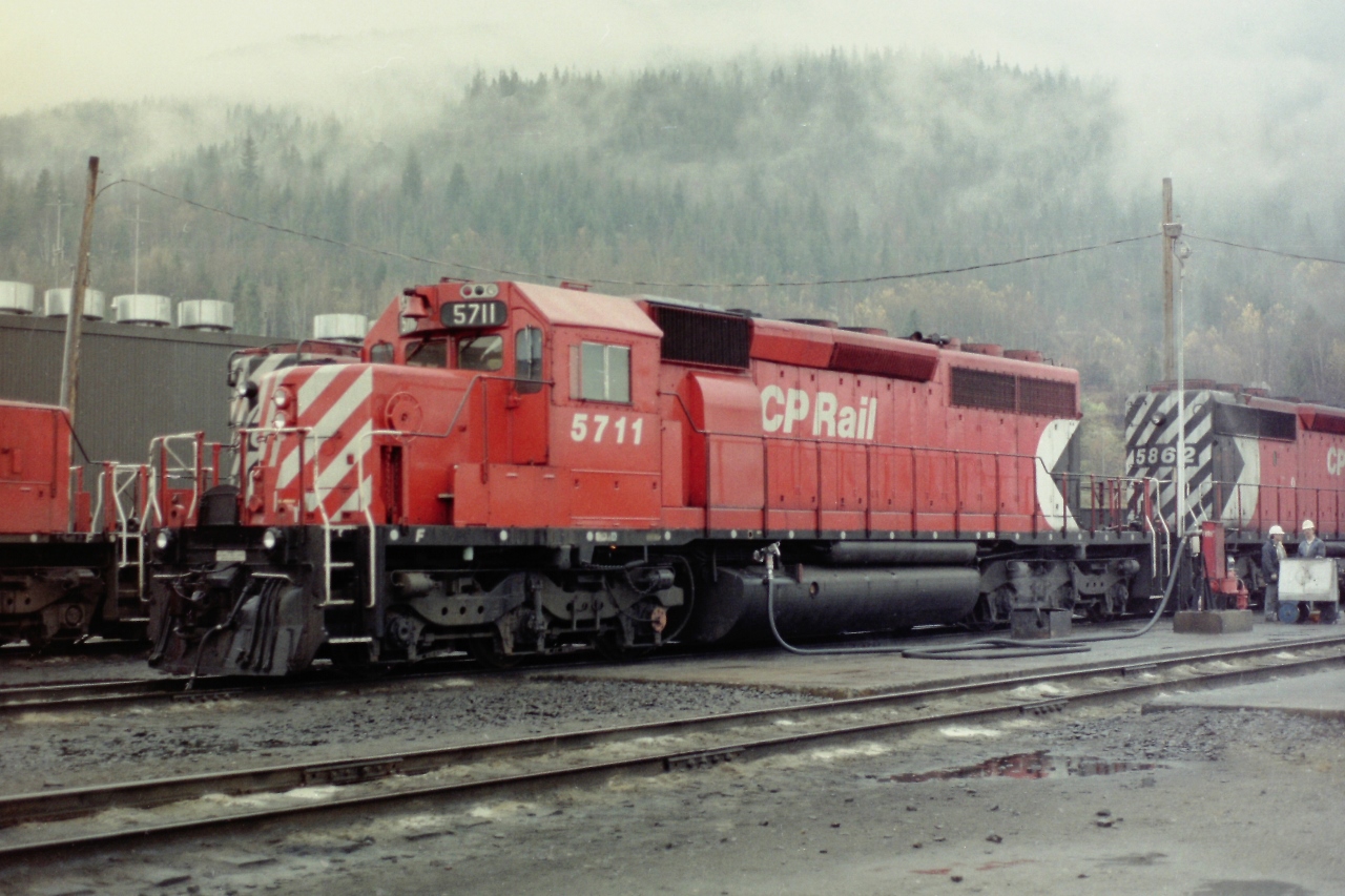 A nice October day in Revelstoke BC! Lots of liquid sunshine and a good hardhat to keep your head dry. Catching locomotives being fulled was not something most people got to see and I was lucky enough be there at the right time. I did what I normally would have done. I just stayed well back and took photographs. Very seldom did I ever talk to a CP employee, I just kept my pass handy and observed. Too this day I have no idea how much fuel locomotives like CP 5711 would have carried in their tanks, nor do I know how far they went with a full tank. Especially in the mountains.