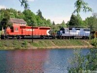 CP SD40-2 5996 leads leased Conrail GP38 7773 on a freight heading eastbound past the pond at Campbellville on a sunny day in May 1985.