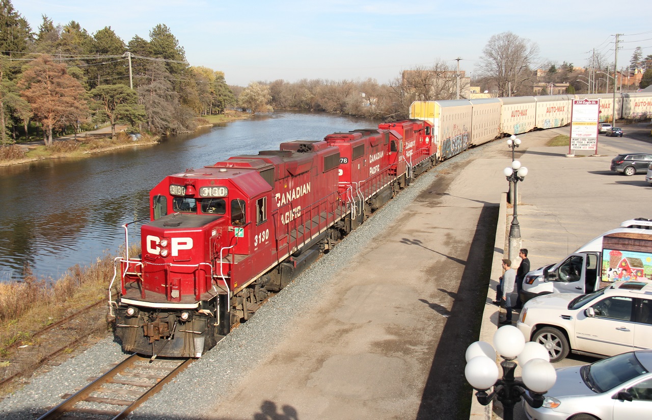 On an unseasonably warm November day, CP 3130, CP 3076 and a newer model ECO GP unit lead a train northbound on the Waterloo Sub towards the Toyota plant, as some onlookers take notice of the movement during a work break.