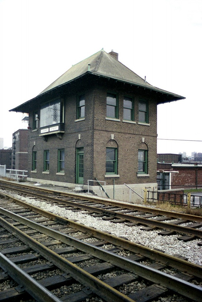 Here's a view of the old Cherry St. Interlocking Tower that one would be hard pressed to get today. This structure was built in 1930-31 and is due to be decommissioned in 2020 when Metrolinx upgrades the signal system. Also, future plans for track expansion means the old building's life at this location is very limited. Mainly because it is in the way.  However it was designated Metrolinx Heritage Property of Provincial Significance in 2013, so the only recourse is to move it. And that is the plan.
This view, if possible without being run down or arrested :o)these days would show a couple of tall glass condo towers crowding the background. Such is life in the Distillery District.