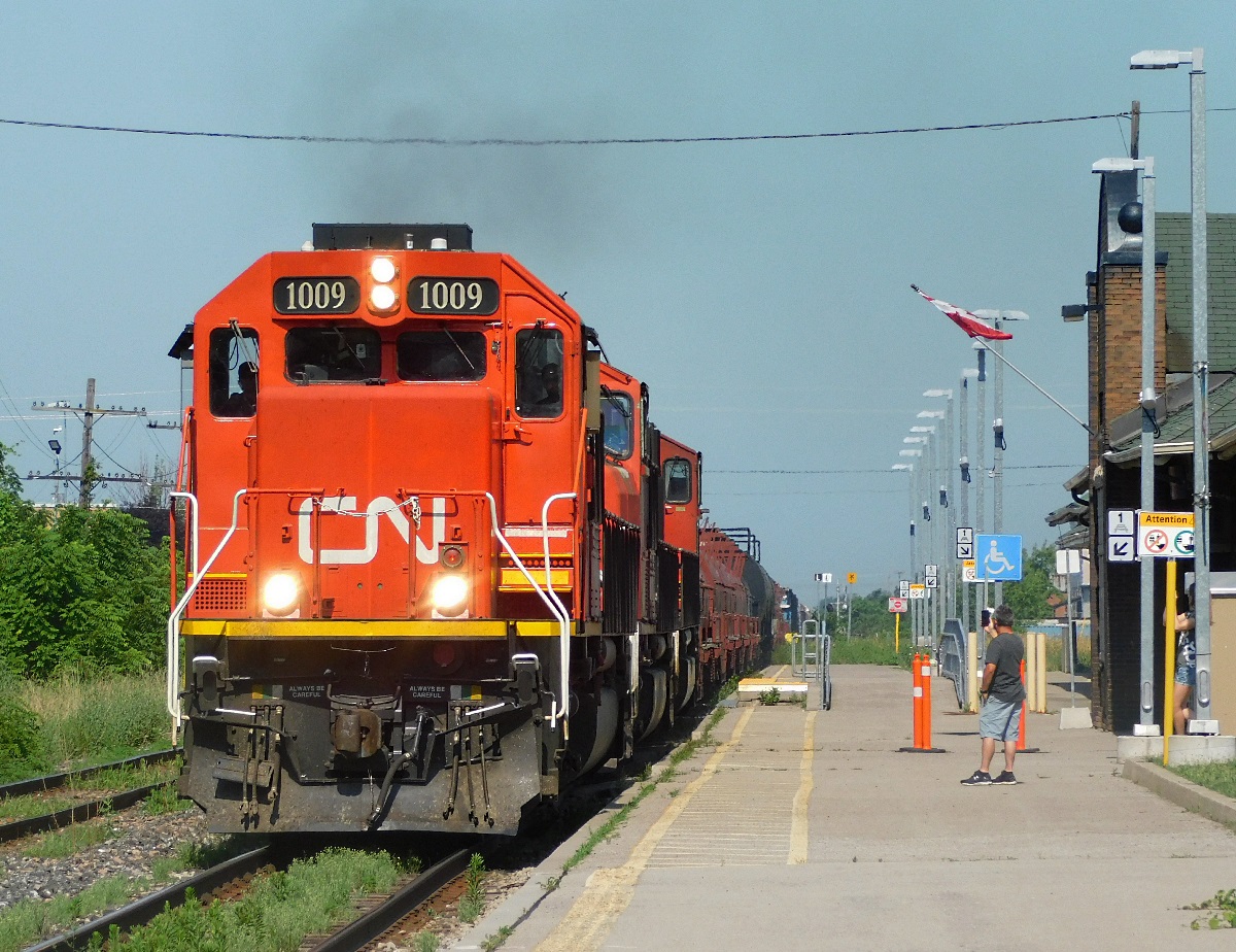 CN A421 rolls through the St. Catharines VIA station on its way to Port Robinson on a boiling Canada Day. Though the leader was repainted it's always fun to see a standard cab EMD, especially a rarity such as the EMD SD70.