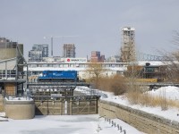 A transfer is entering the Port of Montreal as it passes the eastern end of the Lachine Canal, with GMTX 2257 leading a short cut of cars.