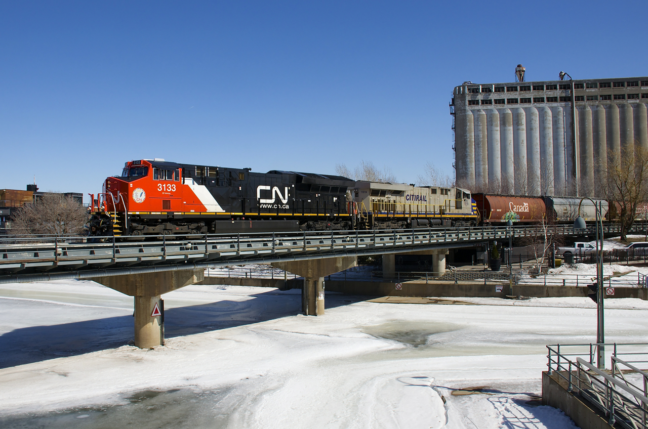 A second section of CN 527 (L52721-26) is entering the Port of Montreal with 51 grain cars. Power is fairly new ET44AC CN 3133 and leased ES44AC CREX 1519. With temperatures still below freezing, the Lachine Canal has not begun to thaw out yet.