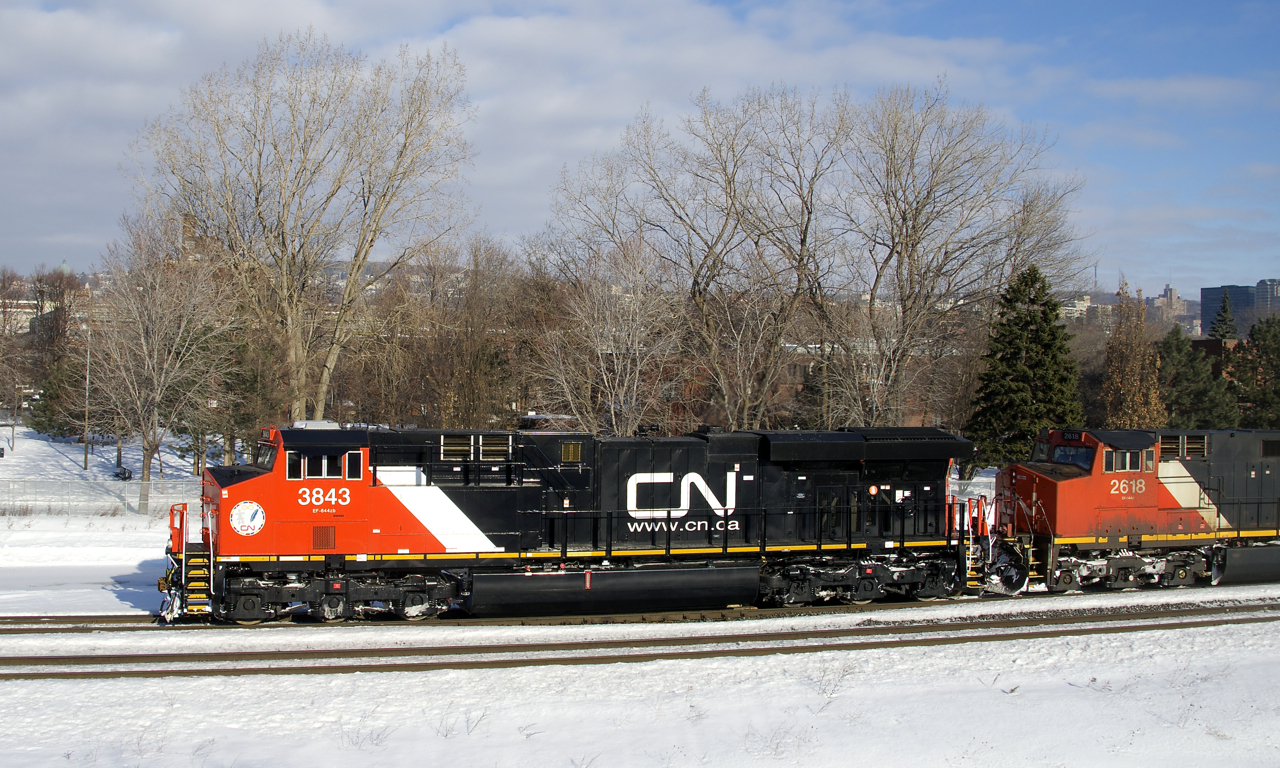 Nearly brand new Tier 4 credit unit CN 3843 leads CN 305 through St-Henri, its spotless appearance in contrast to the grimey CN 2618 which is trailing.