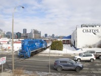 GMTX 2257 is shoving ten grain cars towards the P&H mill as it crosses busy Bridge Street (which leads to the train/auto Victoria Bridge) on track PD10, which only sees rare movements towards this one customer. 