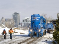 After securing ten grain cars which have just been set off at the P&H mill, the conductor and brakeman walk ahead of GMTX 2257, which they will flag when it crosses the nearby Bridge Street crossing.