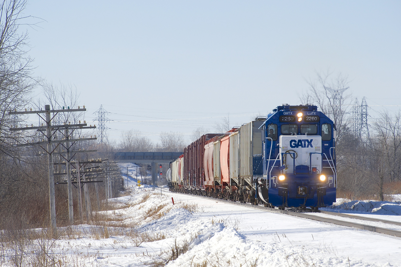 The only freight train that serves the city of Ottawa and surrounding areas (CN 589) is leaving Ottawa for a run down to Coteau after letting VIA 35 and then VIA 26 pass. Leased GP38-2 GMTX 2260 has about fifteen cars in tow as the train starts to pick up speed.