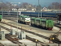 Islington Ave bridge over the yards of GO Transit's Willowbrook and VIA's Toronto Maintenance Centre (since 1985) has been a useful vantage point to see passenger equipment and locomotives since the overpass opened in Dec 1979.<br><br>Much has changed since this picture was taken. By the end of 1990, GO Transit had taken delivery of the majority of their F59PH locomotives, replacing APCU's, APU's, and older locomotives.  Similarly, VIA had completed its fleet of F40PH's. For several years after quite a lot of older equipment was stored in view of this bridge. <br><br>Facing the bridge partly sealed up are APCU GOT 900 and GP40-2W GOT 710 - my Trackside Guide indicates most GO Transit GP40-2W's went to CN in 1991. Three other APCU's face the other way on that siding, plus another to the left.  Single-level GO Transit cab cars and blue VIA coaches can be seen on VIA yard tracks. The top of an LRC locomotive can be seen beyond the closest blue coach. <br>All long gone, and I believe that GO Transit's fueling area was relocated a long time ago.