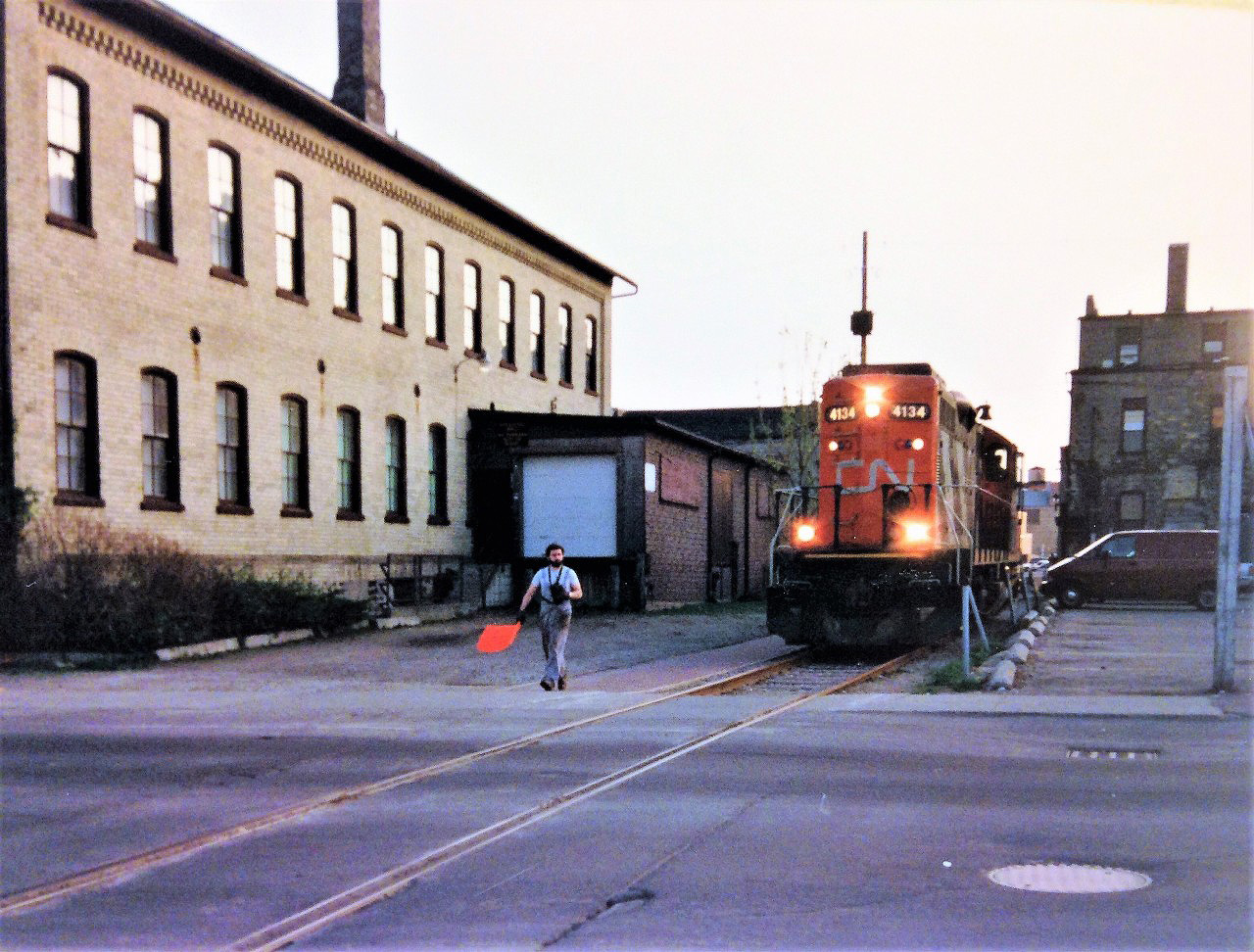 The 15:30 Kitchener Job with GP9RM 4134 is seen approaching Regina Street in downtown Waterloo on the evening of May 6, 1993. The crew has lifted no cars on their southward trip along the Waterloo Spur and will return to Kitchener with just their unit.