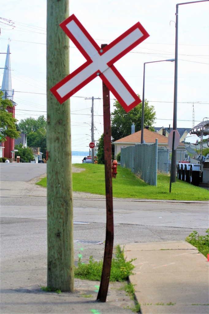 A railway crossing sign mounted on a homemade post guards Ingredion Canada's 1.5 mile industrial spur that connects its former Canada Starch Company (CASCO) facility to the CN Kingston Subdivision at mile 104.8. This was at the first crossing outside the large facility in the town.