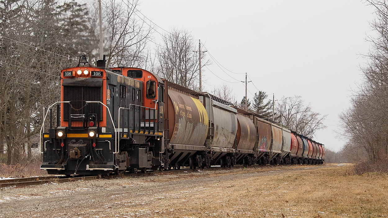 The crew of Trillium 108 has just finished running around their train so that they can continue their journey towards the Port. I quite enjoy grain movement, so this was a fun little chase for me. After building their train at Feeder and WH Yard, they dropped CP interchanged grain at the old Robin Hood mill, and were taking this CN interchanged grain down to the Port Colborne Grain Terminal and ADM. It is my understanding that the old Robin Hood mill only relies on rail when the shipping season is closed for the winter. So I am not sure how many more (if any) unit grain trains like this CP will be interchanging with Trillium until next year. Being on the north side of the train, this was a shot that was afforded by an overcast day. At this particular location, the north side allows for a more favourable, open angle than the south side would. If one was looking to do something similar on a sunny day, you may be able to access a more open south side shot further west at the end of Rosemount Ave.